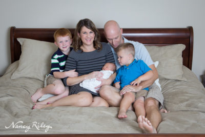 newborn with family on bed