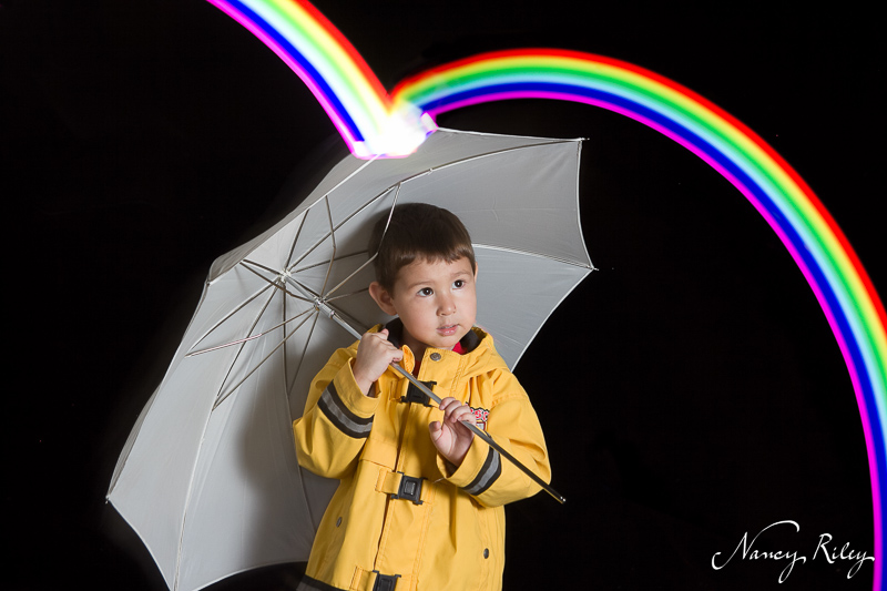 Boy with umbrella and rainbow