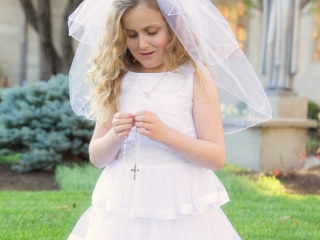 First Communion portrait kneeling in grass