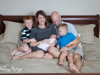 newborn with family on bed