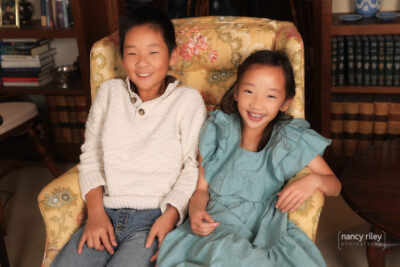 Portrait of boy and girl in chair