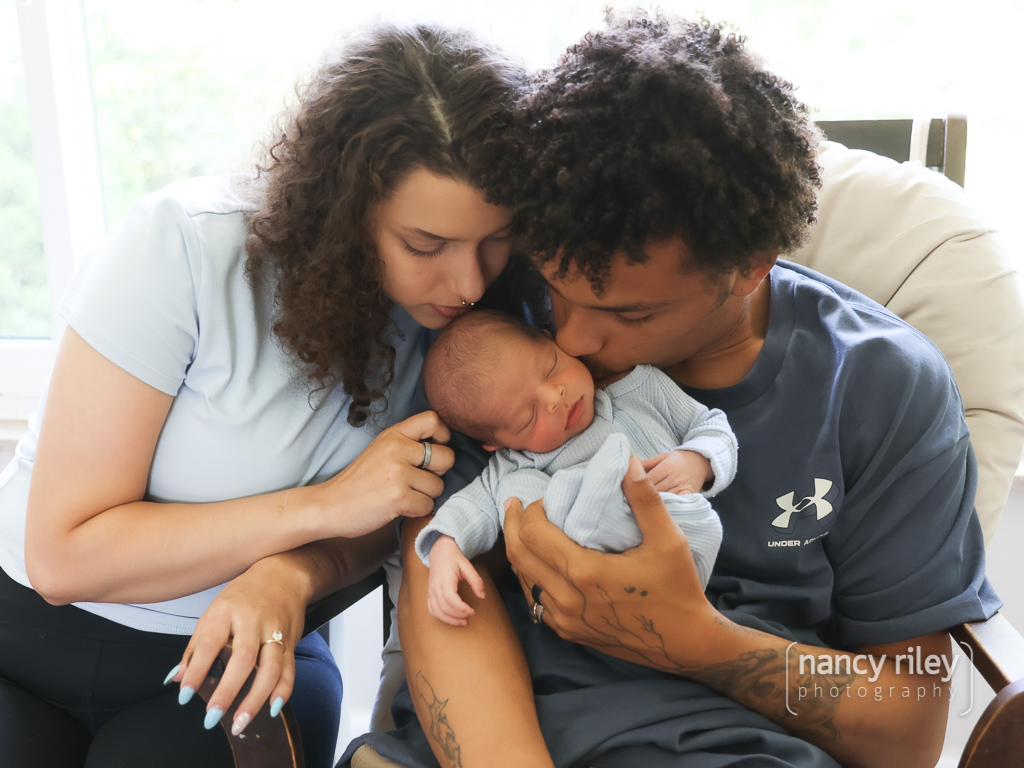 Parents kissing newborn Parents kissing newborn