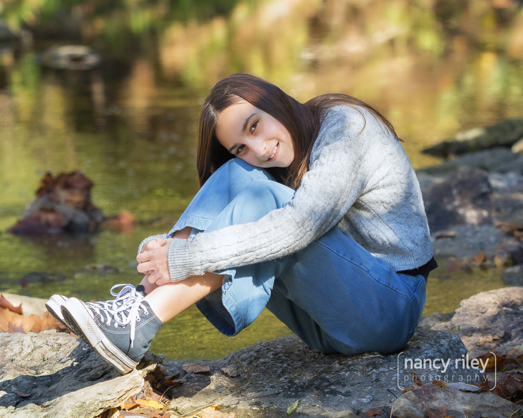 Girl hugging knees in creek Girl hugging knees in creek